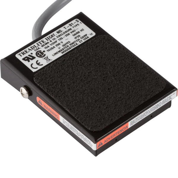 "A black foot pedal with a rectangular plug designed for Fischer Epilator models TS-1, CB-X, and SE-5. The pedal measures 2.5” x 3.5” and includes a 7-foot cord for flexibility in electrolysis treatments."