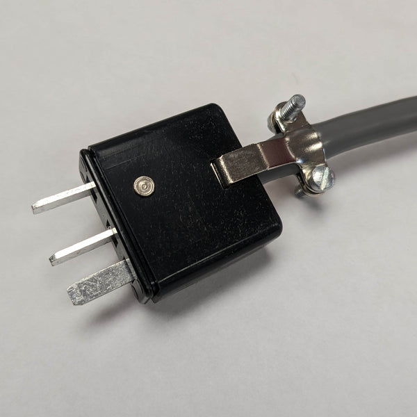 "Black rectangular plug end of a round, silver foot pedal with a black center, designed for use with Instantron and Fischer electrolysis machines. The pedal has a smooth, flat surface for easy foot activation, and connects to the machine with a flexible black cord."