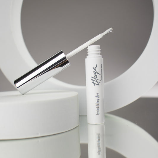 Thuya Eyelash Lifting Glue, clear adhesive for securing lashes during lifts, ensuring strong hold and long-lasting results. small white tube with silver lid, Brush attached to the lid 