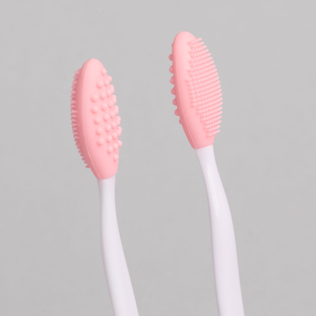 "Exfoliating Eyebrow Brush - A & E Beauty Supplies. pink silicone brush on a white stick"