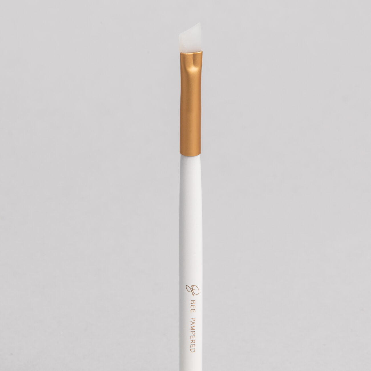 A sleek silicone brush with a flexible, soft tip for precise application of beauty products, brow, lash, and skincare treatments, displayed on a clean, neutral background.