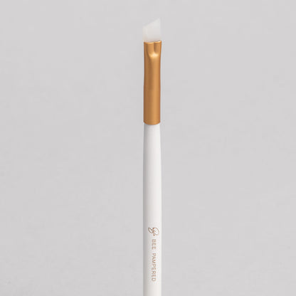 A sleek silicone brush with a flexible, soft tip for precise application of beauty products, brow, lash, and skincare treatments, displayed on a clean, neutral background.