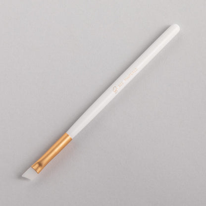 A sleek silicone brush with a flexible, soft tip for precise application of beauty products, brow, lash, and skincare treatments, displayed on a clean, neutral background.